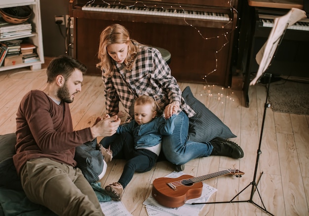 Happy young family playing on the floor  in the room