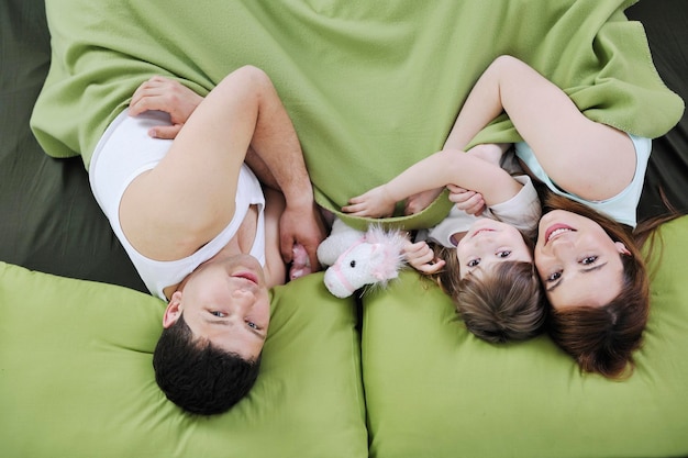 happy young family relaxing in bed