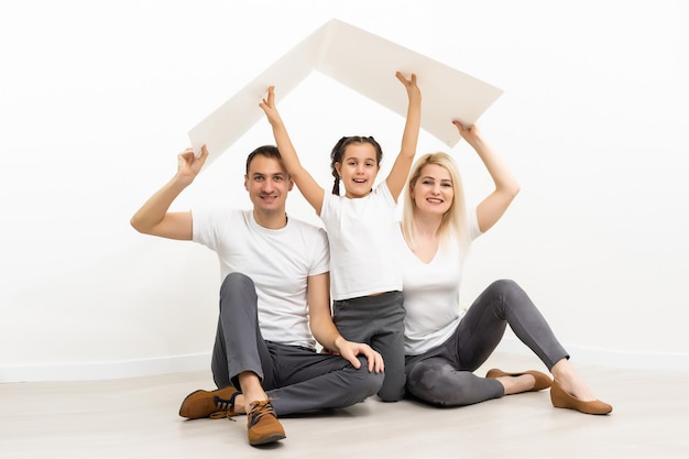 happy young family sitting on floor with home concept.