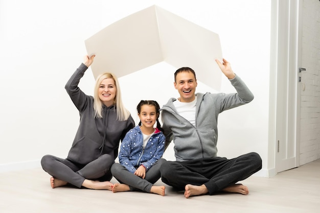 happy young family sitting on floor with home concept.