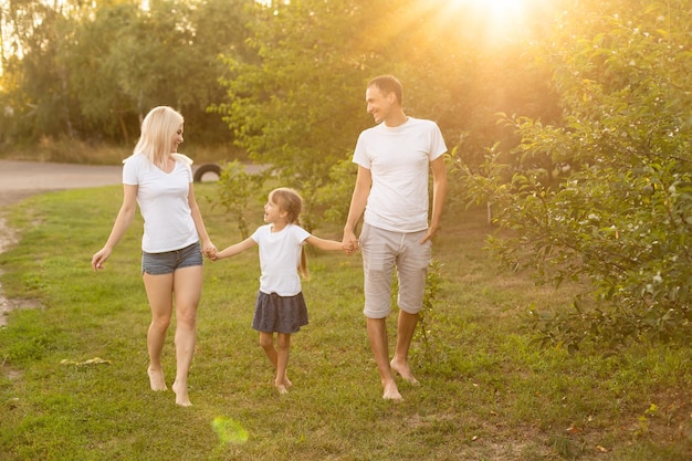 Счастливая молодая семья, проводить время на открытом воздухе в летний день