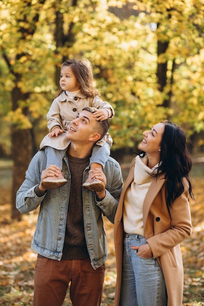 Happy young family spending time together in autumn park