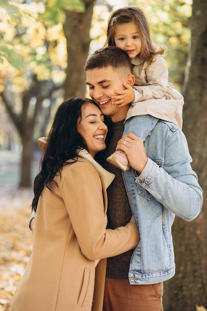 Happy young family spending time together in autumn park