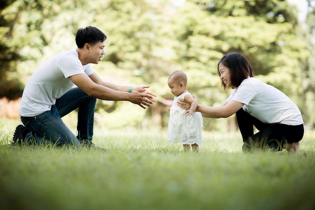 Photo happy young family spending time together outsid,baby walking on the gress