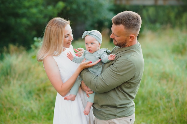 Happy young family spending time together outside in green nature.