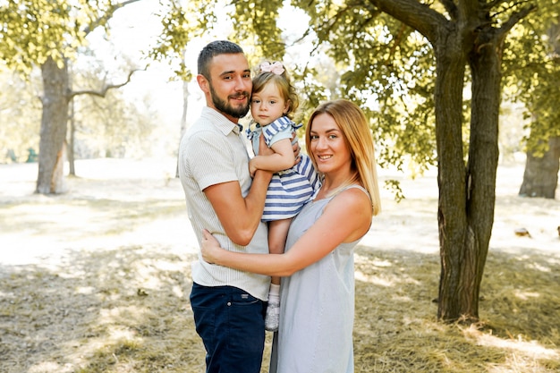 Happy young family spending time together outside in green nature