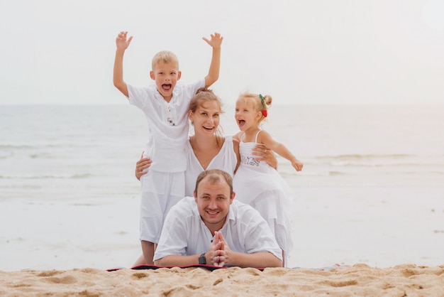 Happy young family on the sunset at the beach.