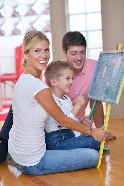 写真 幸せな若い家族はレッスンを教え、自宅で絵を描きながら息子の学校の準備をします