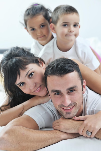 happy young Family in their bedroom have fun and play in bed