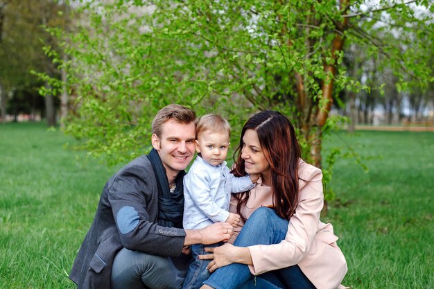 Foto felice giovane famiglia che cammina in un parco cittadino