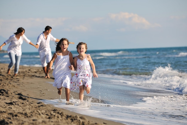 happy young family in white clothing have fun and play with beautiful dog at vacations on beautiful beach