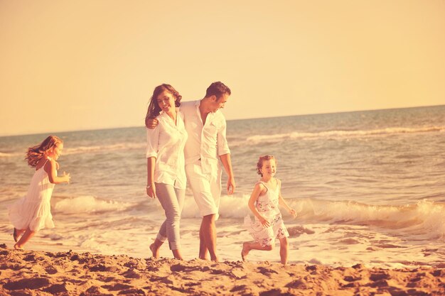 happy young family in white clothing have fun at vacations on beautiful beach