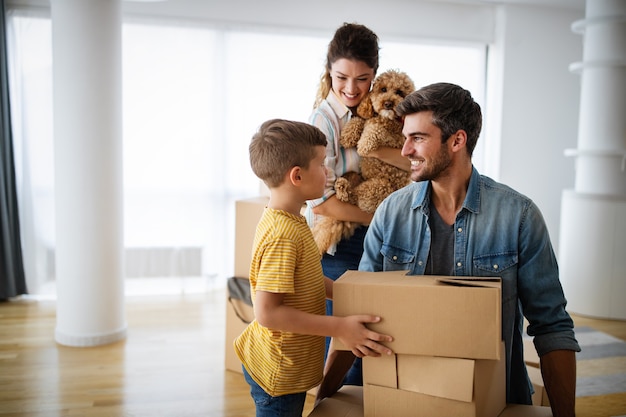 happy young family with children moving with boxes in a new apartment house.