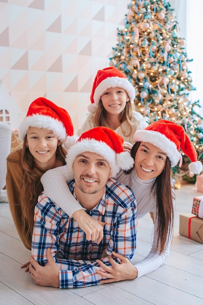 Счастливая молодая семья с детьми, держащими рождественские подарки