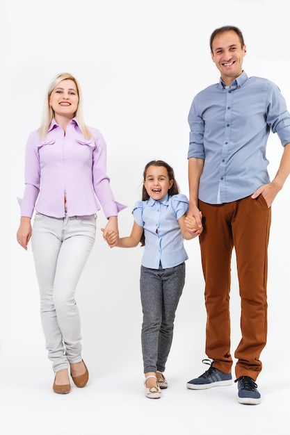 Happy young family with pretty child posing on white background