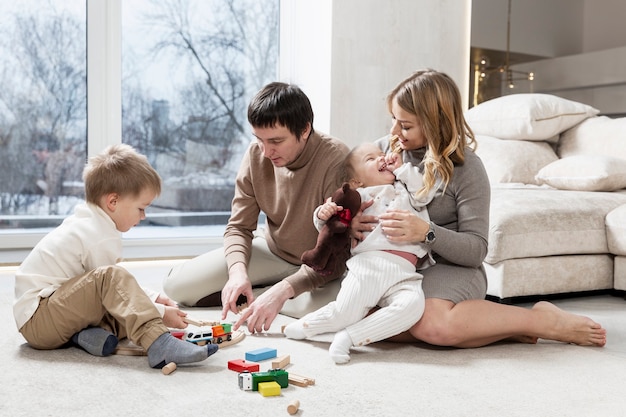 Happy young family with small children are resting in the living room.