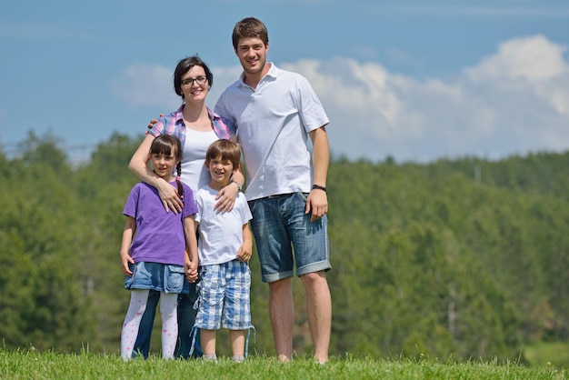 happy young family with their kids have fun and relax outdoors in nature with blue sky in background