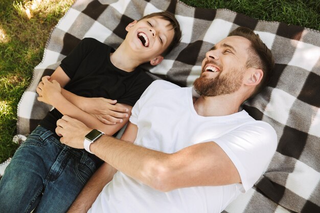 Foto il giovane padre felice si diverte con il suo piccolo figlio