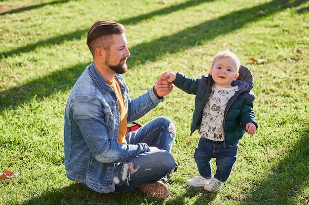 Happy young father walking with his little son