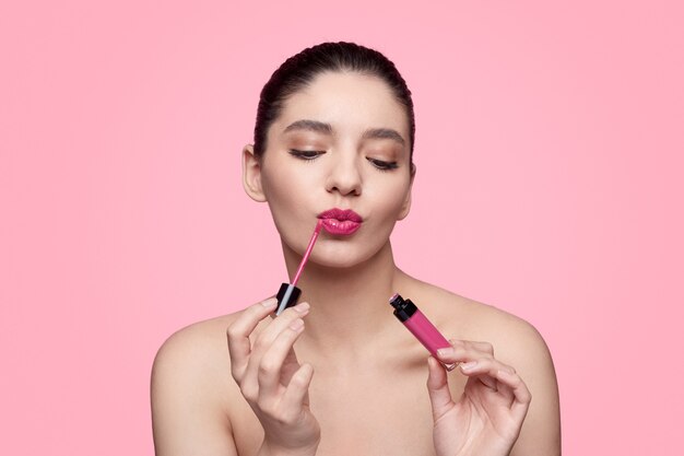 Happy young female against a pink background