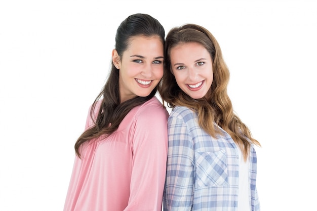 Happy young female friends standing back-to-back