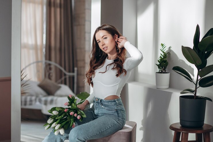 女性の日を祝っている間、笑顔でチューリップの花束を保持している幸せな若い女性