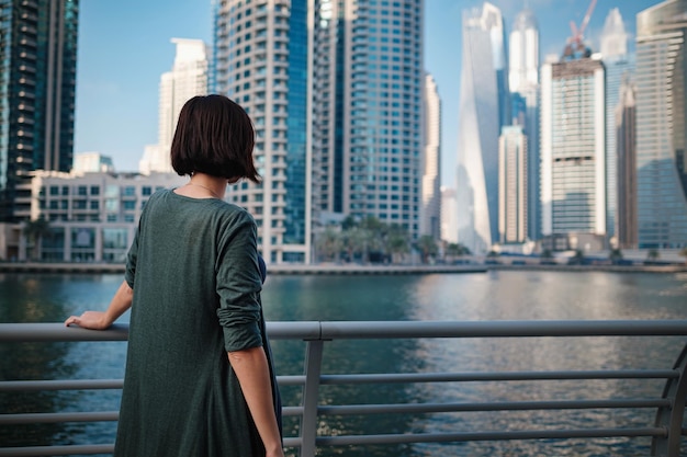 Happy young female traveler in the big city of Dubai UAE