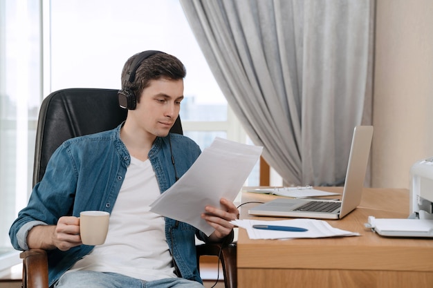 Photo happy young freelancer in headphones working remotely from home office