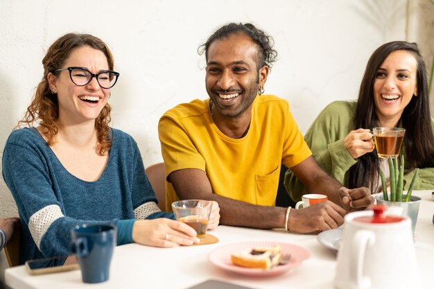 コーヒー ショップで幸せな若い友達のたまり場朝食で船を持っている多民族の大学の学生