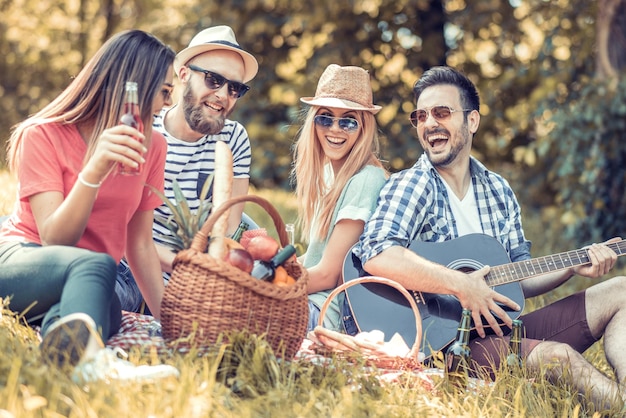 Happy young friends having picnic in the park