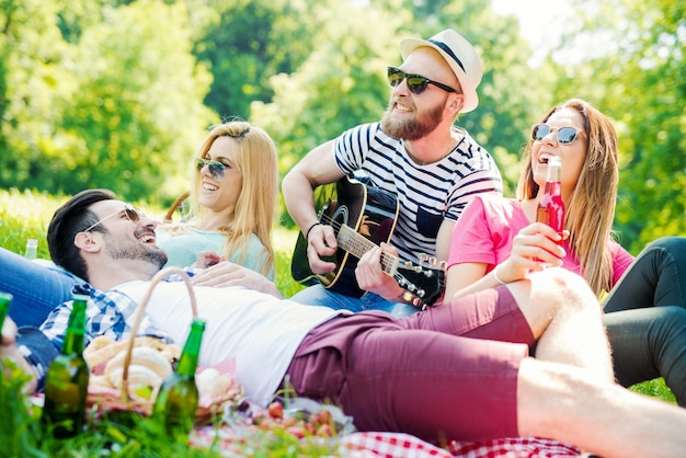 Happy young friends having picnic in the park