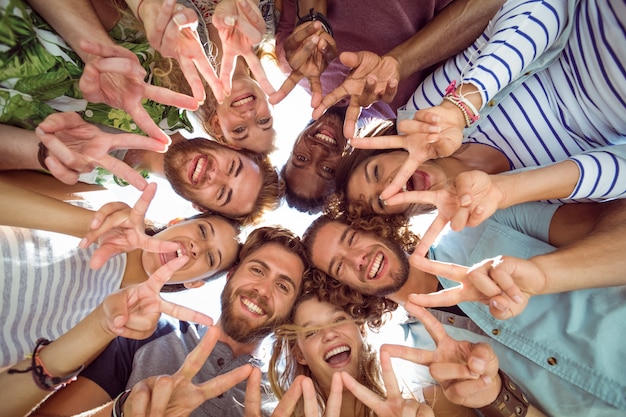 Happy young friends putting hands together