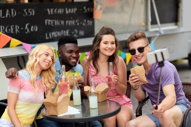 Photo happy young friends taking selfie at food truck