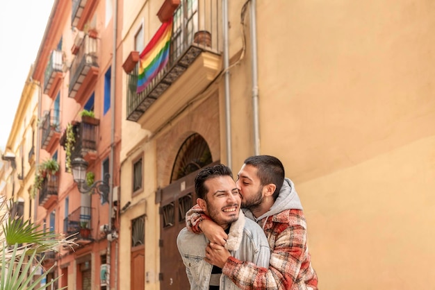 Happy Young gay couple hugging and kissing at the city