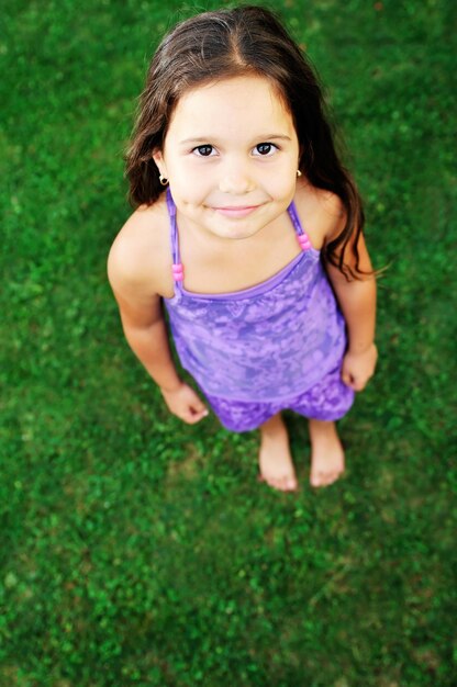 Foto i bambini felici della ragazza si rilassano e si divertono sull'erba con il fiore