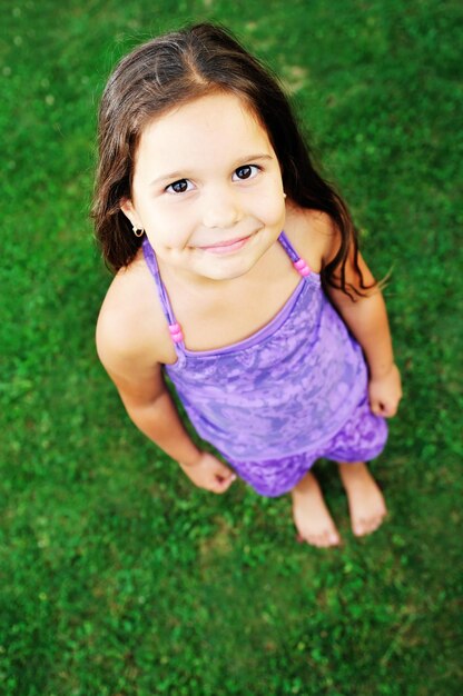 happy young girl children relax lie and have fun on grass with flower