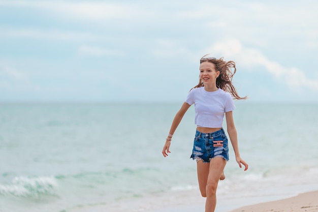 La ragazza felice gode della vacanza tropicale della spiaggia