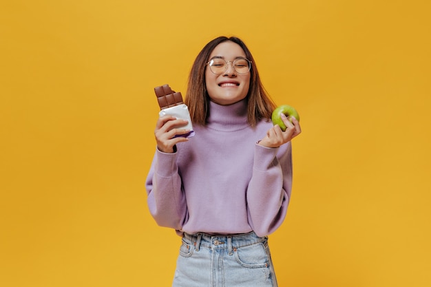 Happy young girl in eyeglasses smiles with closed eyes