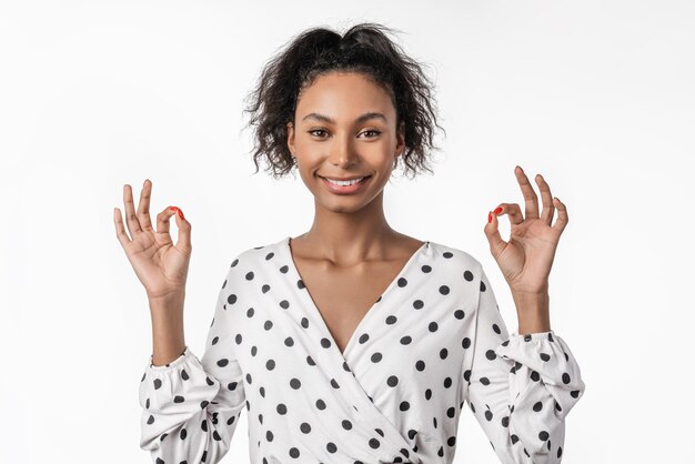 Happy young girl gesturing ok sign isolated over white background