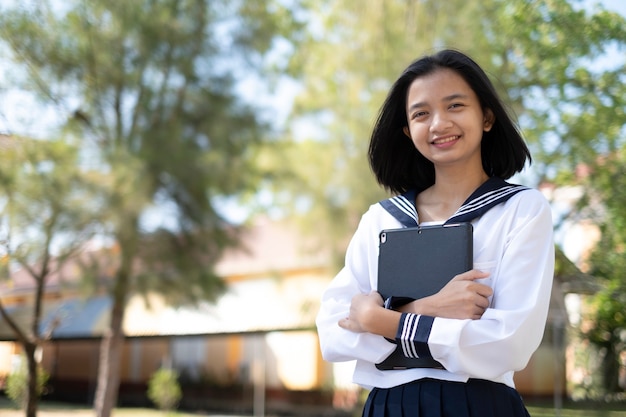 Happy young girl hold laptop at school