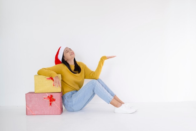 Happy young girl hold present box , Asian girl wear yellow sweater on white background.