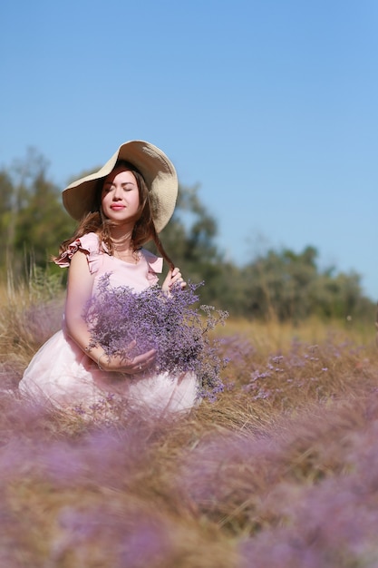 Happy young girl holding bouquet wildflowers in hands