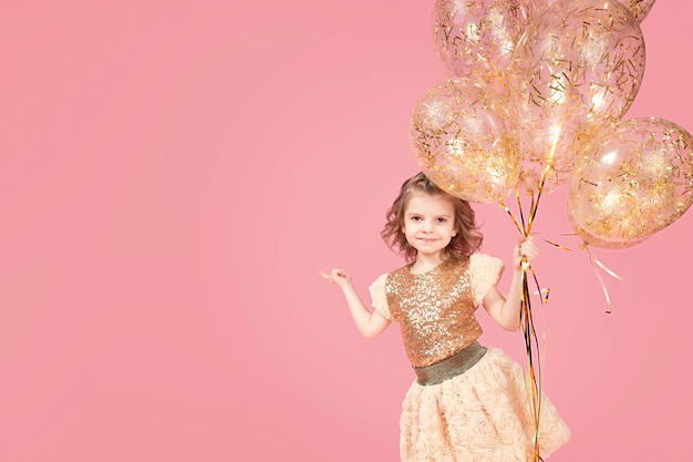 Happy young girl holding bunch of balloons