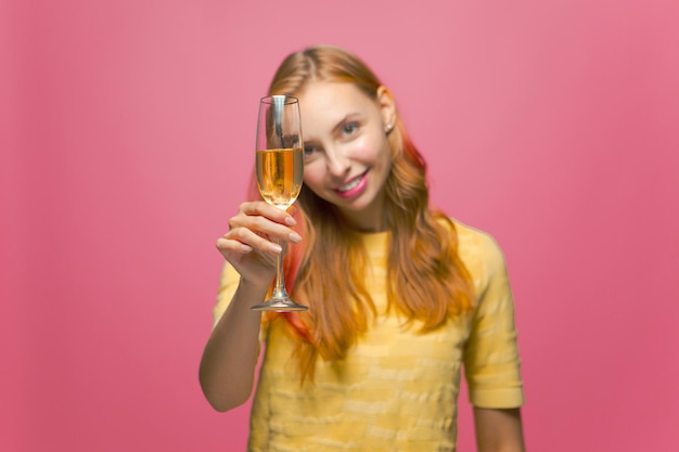 Happy young girl holding glass with champagne celebrating holiday event congratulating partying on
