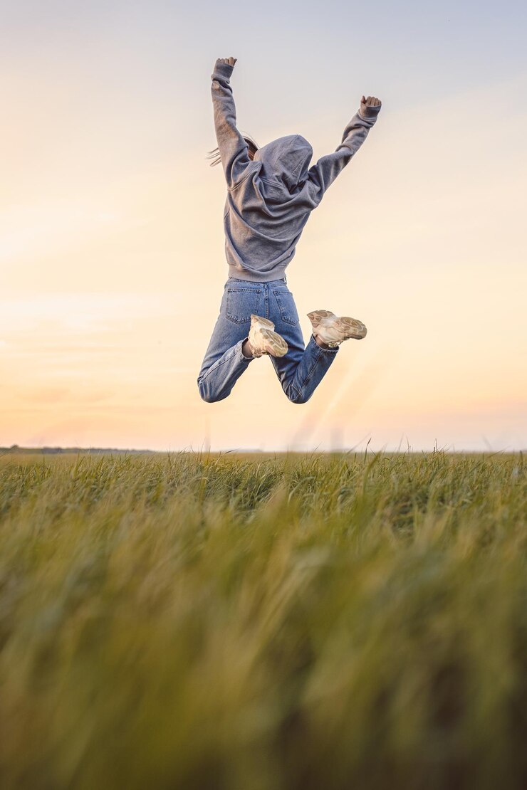 Photo happy young girl jumping with nice sky