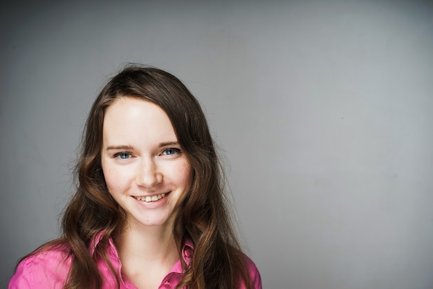 Happy young girl office worker in a pink shirt smiling