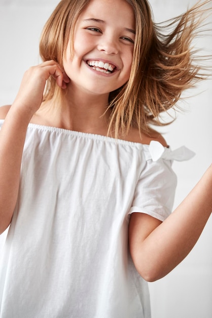 Happy Young Girl Posing In Studio Against White Wall