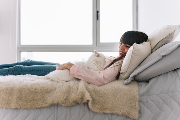 写真 彼女の猫とポーズをとっている幸せな少女