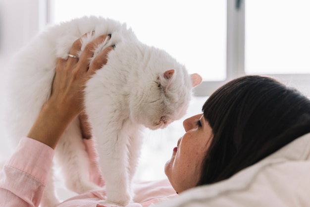 彼女の猫とポーズをとっている幸せな少女