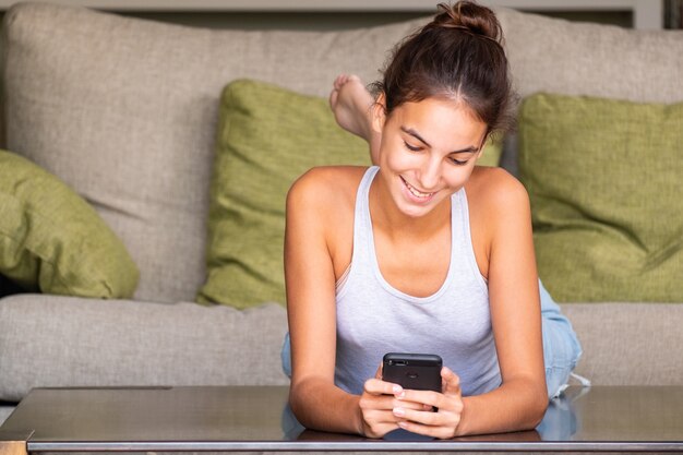 Happy young girl reading a message in a smartphone